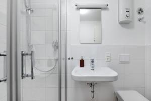 a white bathroom with a sink and a shower at Rieslingglück in Trittenheim +9 photos
