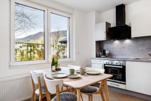 a kitchen with a wooden table and chairs and a window at Rieslingglück in Trittenheim