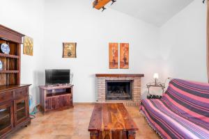 a living room with a couch and a fireplace at Chalet Villa Ariza in Cádiz