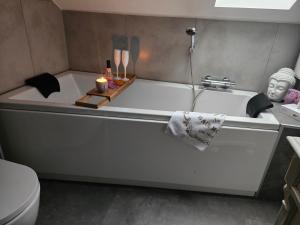 a bathtub with a statue of a head and candles at Ferienwohnung Solling-Lounge in Holzminden +22 photos