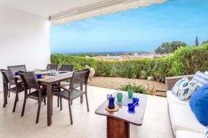 a patio with a table and chairs and a couch at Vista Faváritx in Es Mercadal