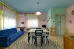 a living room with a blue couch and a table and chairs at Paolo e Francesca in Bosa Marina