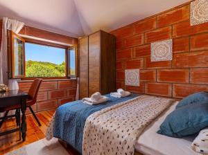 a bedroom with a bed and a brick wall at Stone oasis Marin in Žrnovo +36 photos