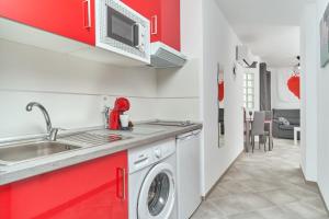 a kitchen with red cabinets and a washing machine at Nerja Boutique 103 Sweet Corner in Nerja