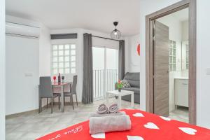 a bedroom with a red bed and a dining room at Nerja Boutique 103 Sweet Corner in Nerja