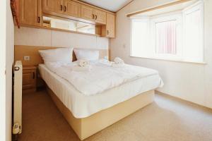 a bedroom with a large white bed with a window at Villa Hexengericht in Thale