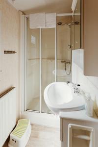 a white bathroom with a sink and a shower at Villa Hexengericht in Thale +35 photos