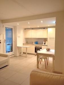a kitchen with white cabinets and a table in it at Domus cinque in Borghetto Santo Spirito