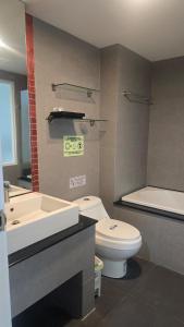 a bathroom with a toilet and a sink and a tub at joyful the Kris406 in Ban Lum Fuang