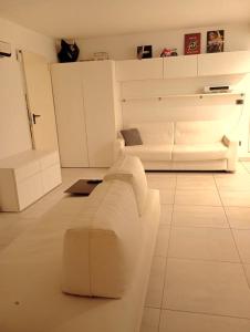 a living room with a white couch in a room at Domus cinque in Borghetto Santo Spirito