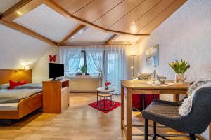a bedroom with a bed and a desk in a room at Gästehaus Absbachtal in Bad Rippoldsau-Schapbach