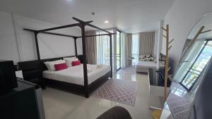 a bedroom with a canopy bed and a balcony at joyful the Kris406 in Ban Lum Fuang