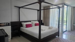 a bedroom with a canopy bed with pink pillows at joyful the Kris406 in Ban Lum Fuang +12 photos