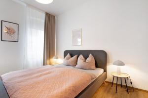 a bedroom with a bed with white walls and a window at Ferienwohnung Finsterwalde 2 in Finsterwalde