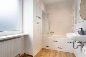 a bathroom with a sink and a bath tub at Ferienwohnung Finsterwalde 2 in Finsterwalde +13 photos