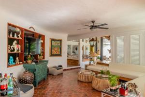 a living room with a couch and a tv at Ocean View Villa, Pool, BBQ, Jacuzzi, Staff Incl in Cajuiles