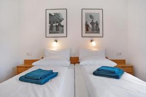 two beds in a room with blue towels on them at Gästehaus Heinemann - Og5 in Langenargen