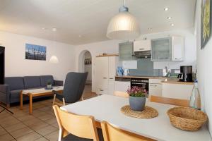 a kitchen and living room with a table and chairs at Gästehaus Heinemann - Og5 in Langenargen