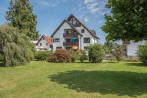 a large white house with a grass yard at Gästehaus Heinemann - Og5 in Langenargen