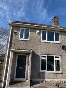 a house with a blue door and windows at Rowe Terrace Workington in Workington