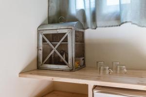 a metal appliance sitting on top of a wooden shelf at En Tino Basement 5 in Tinos