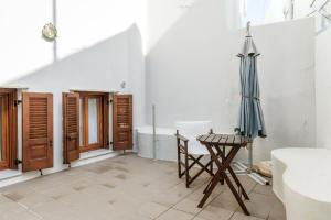 a room with an umbrella and a table and a tub at En Tino Basement 5 in Tinos +13 photos