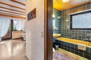 a bathroom with a yellow tub and a sink at Gästehaus Absbachtal in Bad Rippoldsau-Schapbach +106 photos