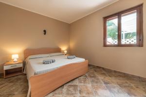 a bedroom with a bed and a window at Le Sabbie Bianche in Calasetta