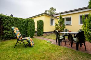 a patio with chairs and a table in a yard at Prerow Am Deich - Ferienwohnung 4 in Prerow