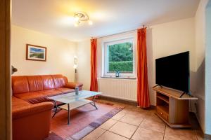 a living room with a couch and a flat screen tv at Prerow Am Deich - Ferienwohnung 4 in Prerow