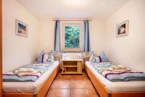 two beds in a small room with a window at Prerow Am Deich - Ferienwohnung 4 in Prerow