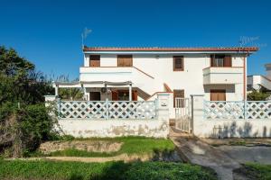 a white house with a white fence at Le Sabbie Bianche in Calasetta