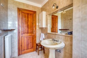 a bathroom with a sink and a wooden door at Villa Marta in Spoleto