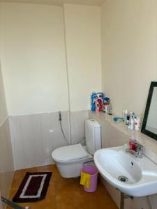a bathroom with a white toilet and a sink at Express view homes in Noida +4 photos
