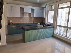a kitchen with white cabinets and a green counter top at Express view homes in Noida