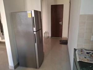 a stainless steel refrigerator in a kitchen with a hallway at Express view homes in Noida