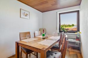 a dining room with a wooden table and a window at Fribo in Ostrach