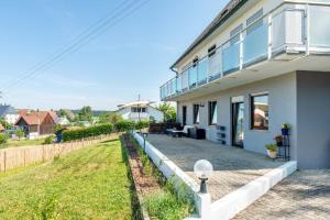 a white house with a patio and grass at Fribo in Ostrach