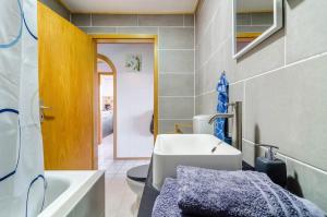 a bathroom with a sink and a toilet and a tub at Fribo in Ostrach +21 photos
