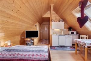 a room with a bed and a kitchen in a cabin at Gästehaus Waldhüsle in Friedenweiler