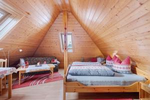 a bedroom with a bed in a wooden attic at Gästehaus Waldhüsle in Friedenweiler