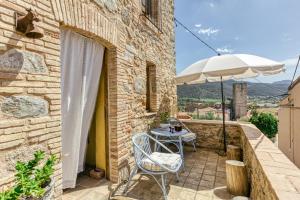 a patio with a table and an umbrella at Casa de Pueblo in Cantallops