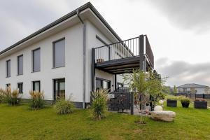 a white house with a staircase on the side of it at Ferienwohnung 20b am Goitzsche See in Pouch