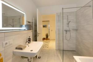 a white bathroom with a sink and a shower at Ferienwohnung 20b am Goitzsche See in Pouch +16 photos