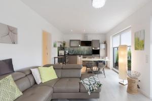 a living room with a couch and a kitchen at Ferienwohnung 20b am Goitzsche See in Pouch