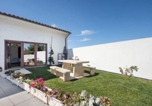 a backyard with a picnic table and grass at Villa com 4 apartamentos in Apúlia