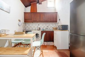 a kitchen with a table and chairs and a refrigerator at Casa Do Castelo in Beja