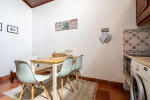 a kitchen with a wooden table and four chairs at Casa Do Castelo in Beja +15 photos