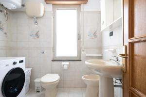 a bathroom with a sink toilet and a window at Sa omu de sa palgia in Jerzu +24 photos