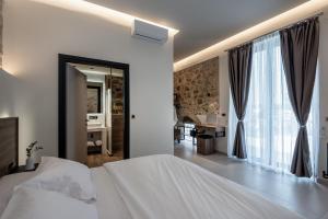 a bedroom with a white bed and a large window at Villa Afroditi - Sfinari in Áyios Nikólaos